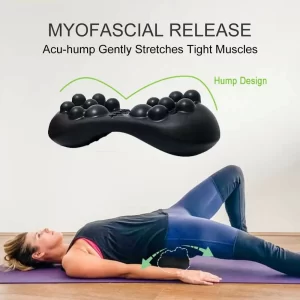 A woman is lying on her back on the floor, her left leg is bent, her right leg is straight, and the Acu-hump massage tool is placed under her hips. She is using Acu-hump to gently massage and stretch her hips for myofascia release