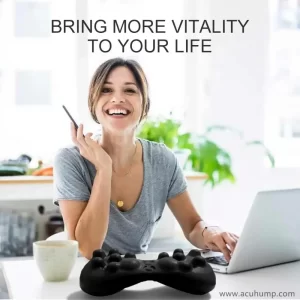 A woman is sitting at a desk with an Acu-hump sciatica massage tool on it, she can use Acu-hump to work easily and happily without suffering from sciatica