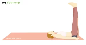 A woman lying on a yoga mat with her legs straight on the wall and put an Acu-hump under her buttocks to stretch and massage her hamstrings and legs for sciatica pain relief