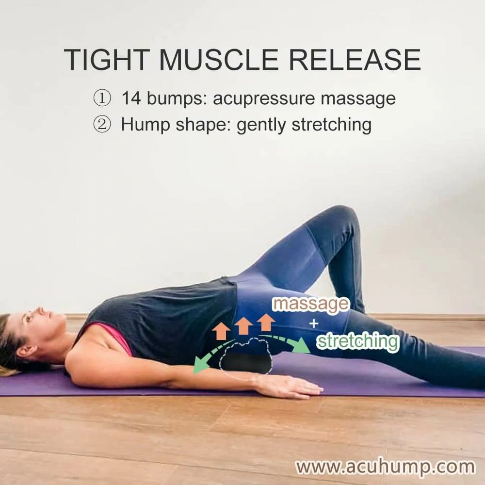 A woman is lying on her back on the floor, her left leg is bent, her right leg is straight, and the Acu-hump massage tool is placed under her hips. She is using Acu-hump to gently massage and stretch her hips for tight muscle release