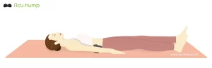 A woman lying on her back on a yoga mat with an Acu-hump tool on her lower back, which massages and stretches her lower back for sciatica relief