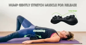A woman is lying on her back on the floor, her left leg is bent, her right leg is straight, and the Acu-hump massage tool is placed under her hips. She is using Acu-hump to gently massage and stretch her hips for myofascia release