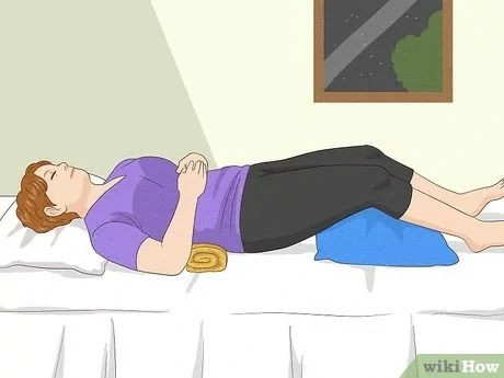 A woman uses pillows to support her lower back and legs to relieve piriformis pain