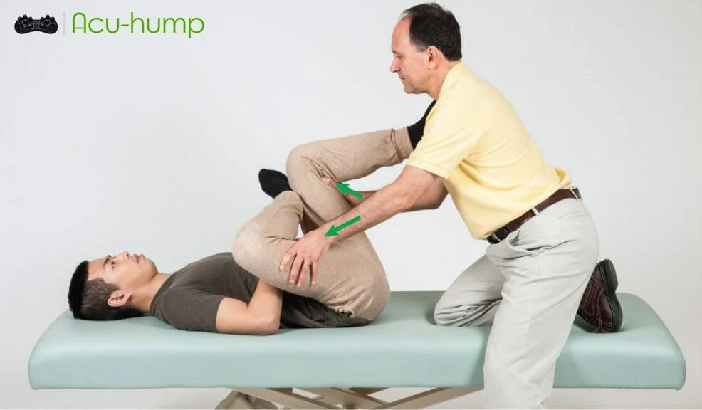 Therapist helps piriformis syndrome patient perform 4-figure stretch