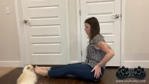 A woman sits on an Acu-hump massage tool to relieve piriformis syndrome by applying pressure to massage the muscles of the buttocks