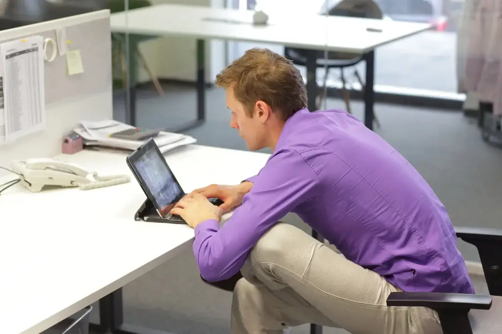 a man with bad sitting habits slouching in chair cause buttocks pain